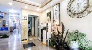 une grande horloge sur le mur d'un bâtiment dans l'établissement Ace Hotel, à To-dong