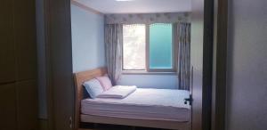 un petit lit dans une chambre avec une fenêtre dans l'établissement Ace Hotel, à To-dong 49 autres photos