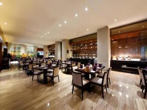 un restaurant avec des tables et des chaises et une cheminée dans l'établissement Kinho Narada Hotel, à Xianliangzhongchang