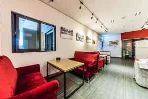a waiting room with red chairs and a table at Line Plus Hotel in Orijŏng