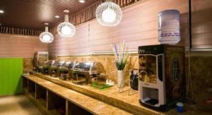 a restaurant with a counter with a row of machines at GreenTree Alliance Nantong Chongchuan Fangtian Market Branch in Nantong