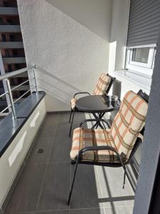 a balcony with chairs and a table and a table at Hari Apartmani Oaza in Tuzla