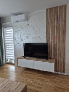 a living room with a flat screen tv on a cabinet at Hari Apartmani Oaza in Tuzla
