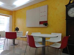 バンコクにあるYour Place Hotelのテーブルと椅子と時計のあるダイニングルーム