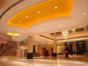 a lobby of a building with a yellow ceiling at Changshu Jinling Tianming Grand Hotel in Changshu +131 photos