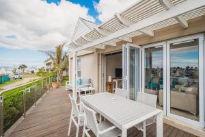 ジョージにあるPalms Manor on Kingswood Golf Estateのパティオ(白いテーブル、デッキの椅子付)