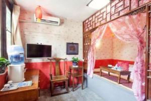 a living room with a red couch and a tv at Pingyao Yufengheng Hotel in Pingyao