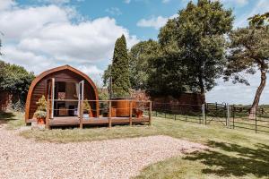 シュルーズベリーにあるSecluded Cosy Luxury Pod with wood fired hot tubの柵で囲まれた野原にある小さなテント