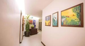 a hallway with many paintings on a wall at Casa Rubin in Angatan