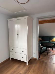 a white cabinet in a living room with a couch at Ferienwohnung Lichterhof in Sebnitz