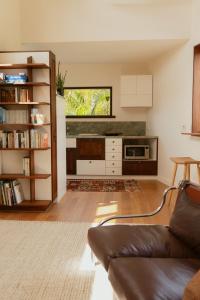 a living room with a couch and a kitchen at Bird & Beach - 2 minutes walk to the beach in Suffolk Park