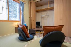 a living room with two chairs and a table at urara house guesthouse in Wada