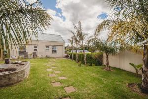 ジョージにあるPalms Manor on Kingswood Golf Estateのヤシの木と白家の庭