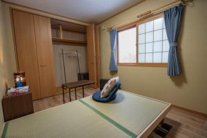 a room with a bed and a window at urara house guesthouse in Wada