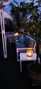 a white bench with a blue pillow on a patio at Palms Manor on Kingswood Golf Estate in George