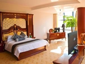 a bedroom with a bed and a desk and a television at Huizhou Wanyun Holiday Hotel in Huangshan +196 photos