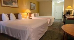 a hotel room with two beds with white sheets at Rodeway Inn Salina North in Salina