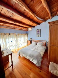 a bedroom with a bed and a wooden ceiling at Casa Alfurán in Alfornón