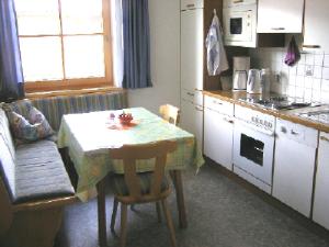 uma cozinha com uma mesa e uma cozinha com um fogão em Haus Pinzger em Fendels