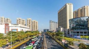 廈門市にあるPeony Harbor City Hotelの高層ビル前の交通量の多い街道