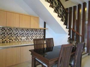 une cuisine avec une table et des chaises ainsi qu'un escalier dans l'établissement AZHIMA Resort and Convention, à Adi Sumarmo Wiryokusumo