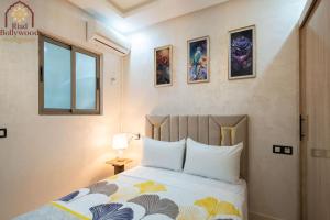 BenguerirにあるRiad Bollywood- UniStayのベッドと窓のある寝室