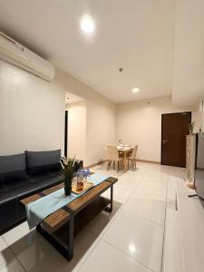 a living room with a black couch and a table at 2BR Sunset View Deluxe Suite in Manila +13 photos