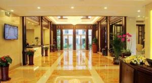 a large lobby with flowers and plants in it at Sky World Hotel Qingdao in Qingdao