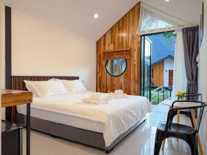 a bedroom with a bed and a large window at Mini Vangvieng Resort in Vang Vieng +15 photos