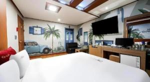 a bedroom with a bed and a flat screen tv at Chuncheon World Hotel in Chuncheon