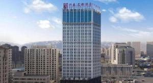 a tall building with a sign on top of it at Inner Mongolia XingTai Phoenix Hotel in Hohhot