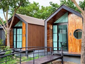 a house with a deck and a tree at Mini Vangvieng Resort in Vang Vieng