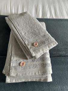 a white towel with two buttons on top of a couch at Gîte 8 pers avec jacuzzi et jardin Aurillac in Arpajon-sur-Cère