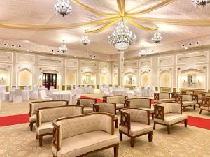 a banquet hall with chairs and tables and a chandelier at Rambagh Resort by Stotrak, Gwalior in Gwalior