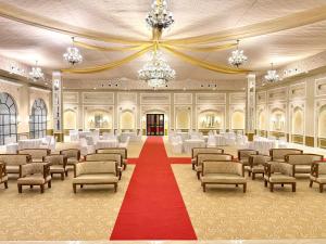 Cette grande chambre est dotée de chaises et d'un tapis rouge. dans l'établissement Rambagh Resort by Stotrak, Gwalior, à Gwalior