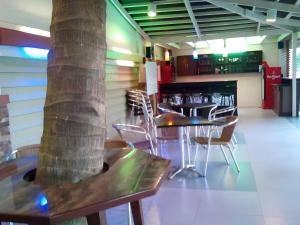 un restaurant avec des tables et des chaises et un arbre dans l'établissement Staylite Candon Hotel, à Candon