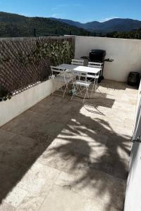 a table and chairs on a patio with a fence at Appartement en bord de mer in Sainte-Maxime