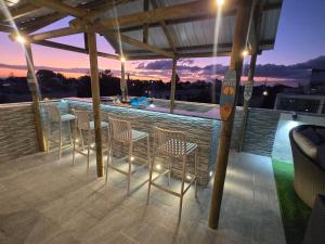 a patio with chairs and a bar on a roof at Villa La Tourelle in Rivière Noire