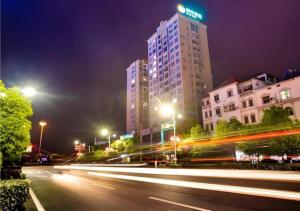 PuqiにあるCity Comfort Inn Chibi Railway Stationの高層ビルが立ち並ぶ夜の街路