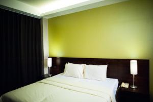 a bedroom with a large bed with a green wall at Baansilom Soi 3 in Bangkok