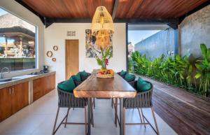 a kitchen with a wooden table and chairs at Luxus Villa Jungle View 3br in Tumbak Bayuh