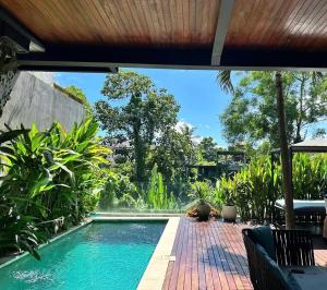 a swimming pool with a view of a garden at Luxus Villa Jungle View 3br in Tumbak Bayuh