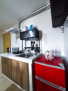 a kitchen with a sink and a red refrigerator at Modern 2BR Escape Overlooking the Iloilo River in Mandurriao