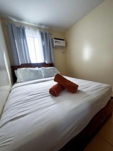 a bed with two towels on top of it at Modern 2BR Escape Overlooking the Iloilo River in Mandurriao