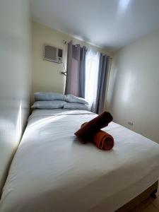 a large white bed in a room with a window at Modern 2BR Escape Overlooking the Iloilo River in Mandurriao +7 photos