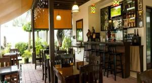 ジェネラル・サントスにあるDriggs Pension Houseのバーとテーブルと椅子のあるレストラン