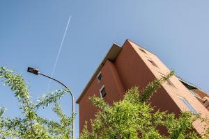 ein hohes rotes Backsteingebäude mit einer Straßenlaterne in der Unterkunft Fiera aperto 24H - Bologna Accommodation in Bologna