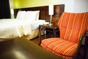 a hotel room with a bed and a chair at Baansilom Soi 3 in Bangkok