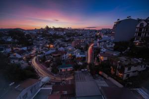 une silhouette de ville la nuit avec une route et des bâtiments dans l'établissement Bee Luxury Dalat Hotel, à Đà Lạt