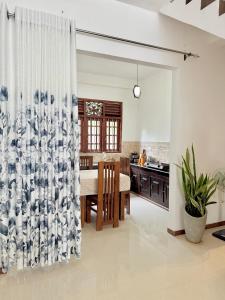 a kitchen and dining room with a table and a curtain at Sasmika Villa Surf and Yoga Hostel in Weligama +35 photos